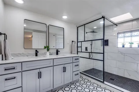 a spacious bathroom with a shower a sink and a mirror