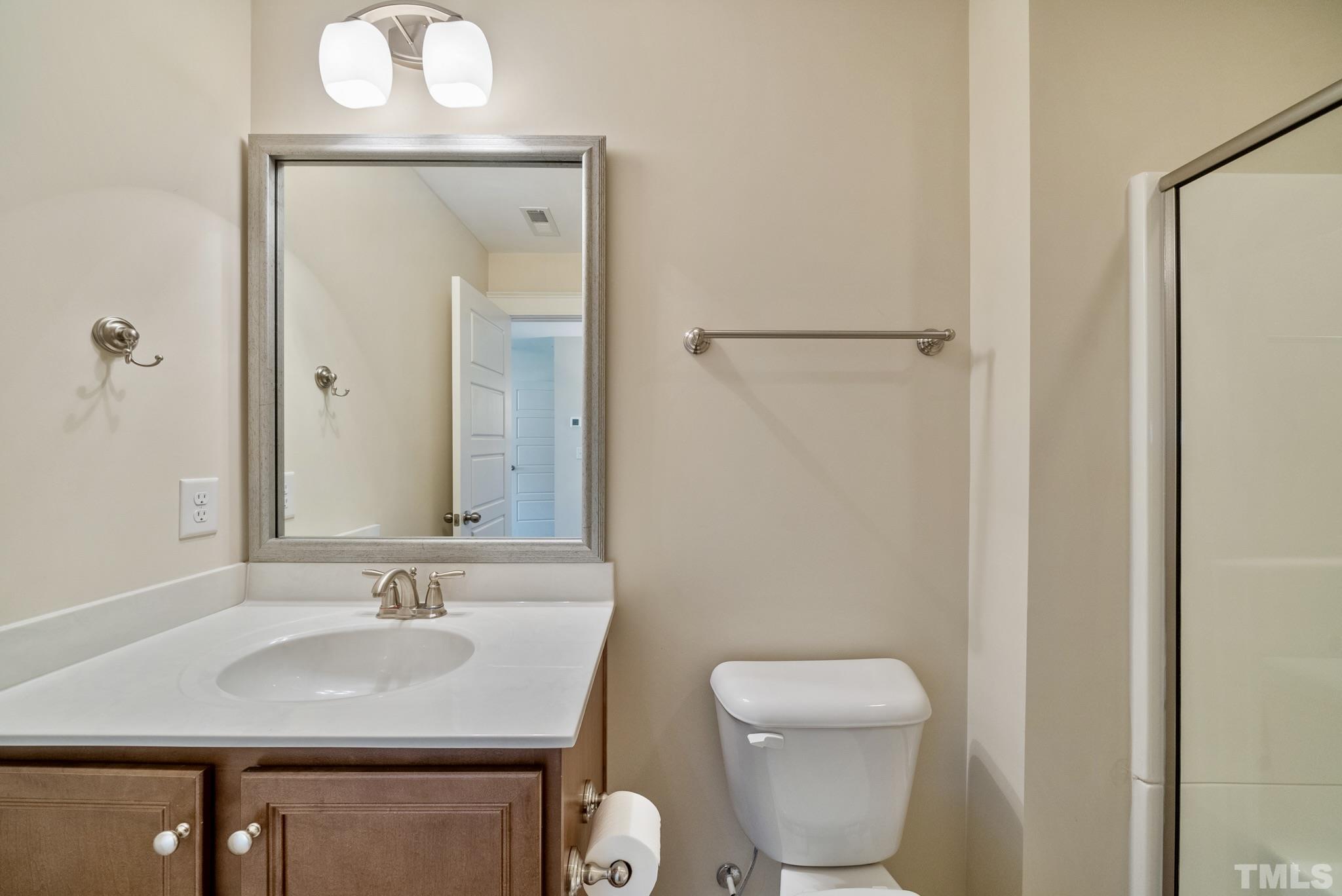 7891 Allscott Way Raleigh, NC 27612 - Photo 25 of 27 a bathroom with a toilet sink and mirror