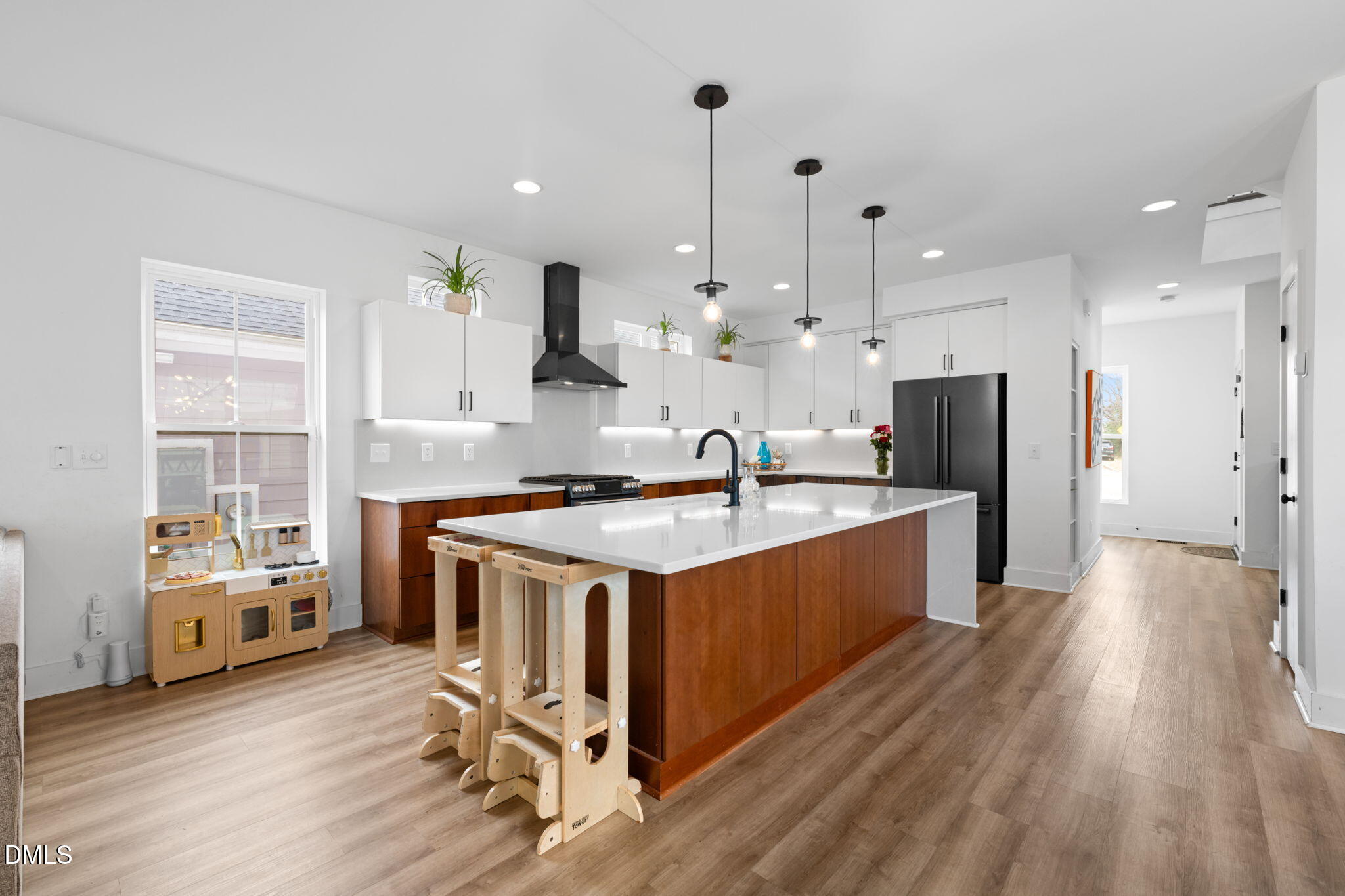 320 South Tarboro Street Raleigh, NC 27610 - Photo 13 of 54 a large kitchen with stainless steel appliances kitchen island granite countertop a stove a refrigerator a sink dishwasher and white cabinets with wooden floor