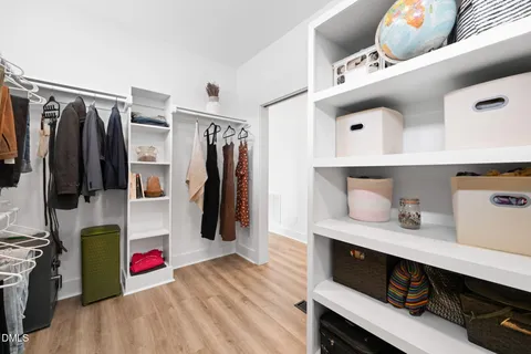 a view of walk in closet with clothes and shoes
