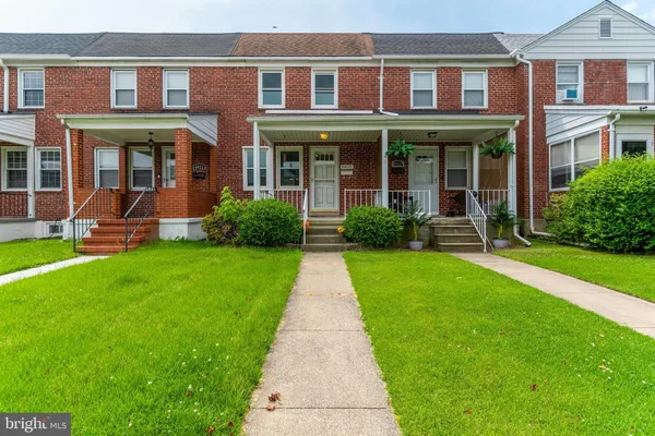 front view of a brick house with a yard