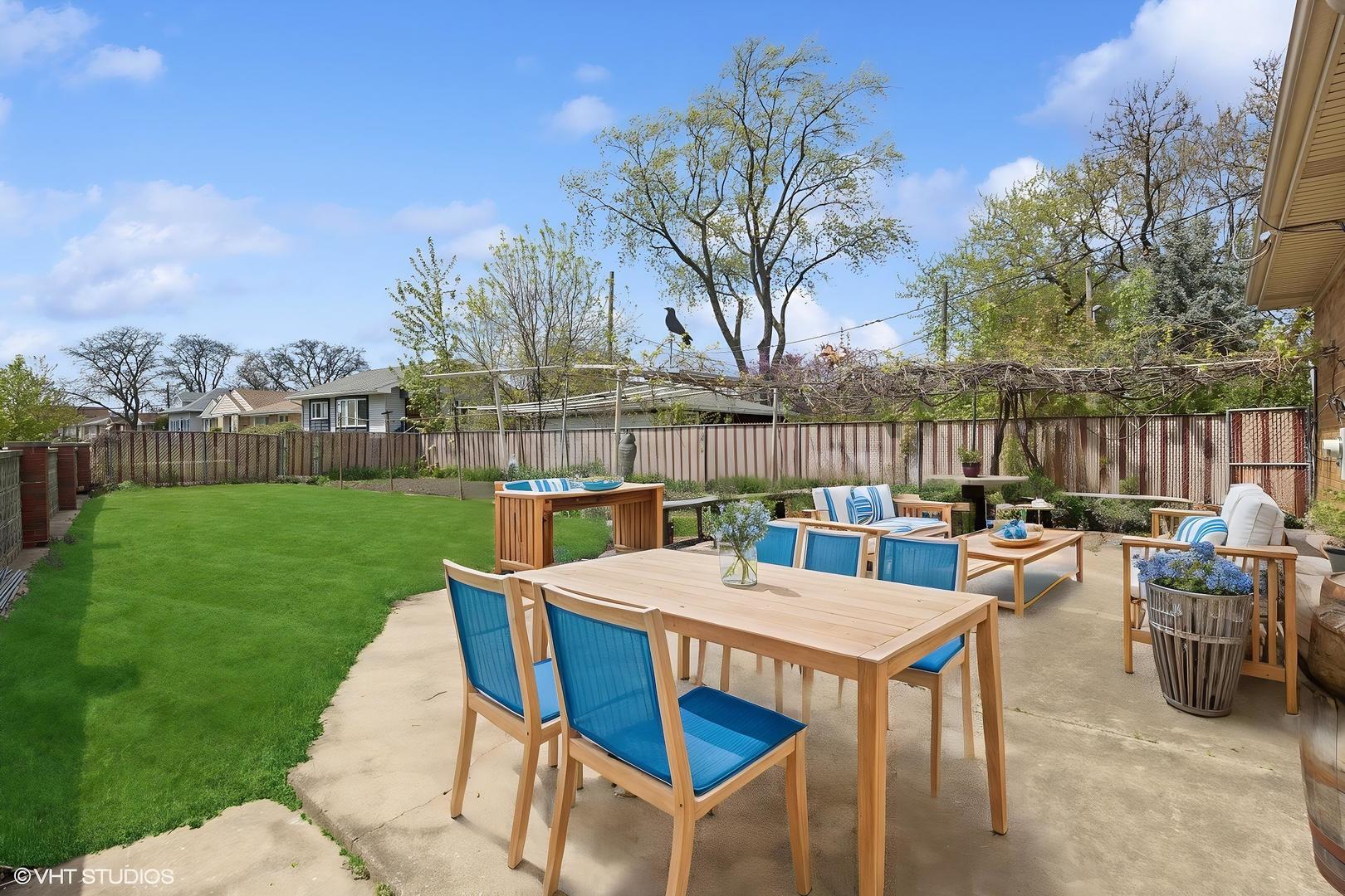 7010 West Devon Avenue Chicago, IL 60631 - Photo 46 of 51 a view of a patio with table and chairs and potted plants with wooden fence