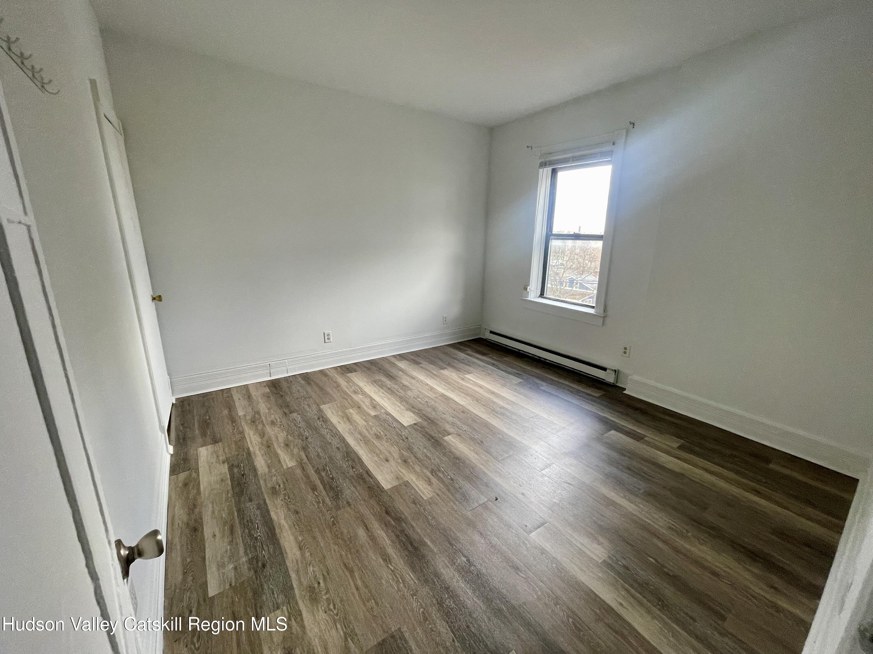 426 Warren Street, Unit 3 Hudson, NY 12534 - Photo 12 of 13 an empty room with wooden floor and windows