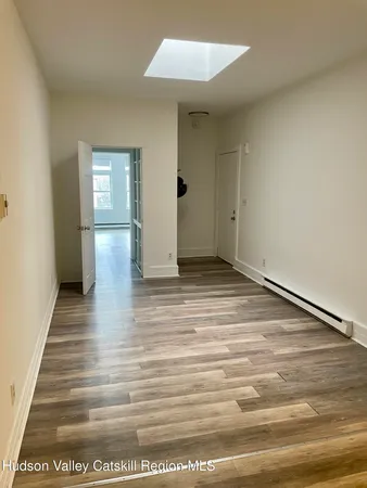 a view of a room with wooden floor
