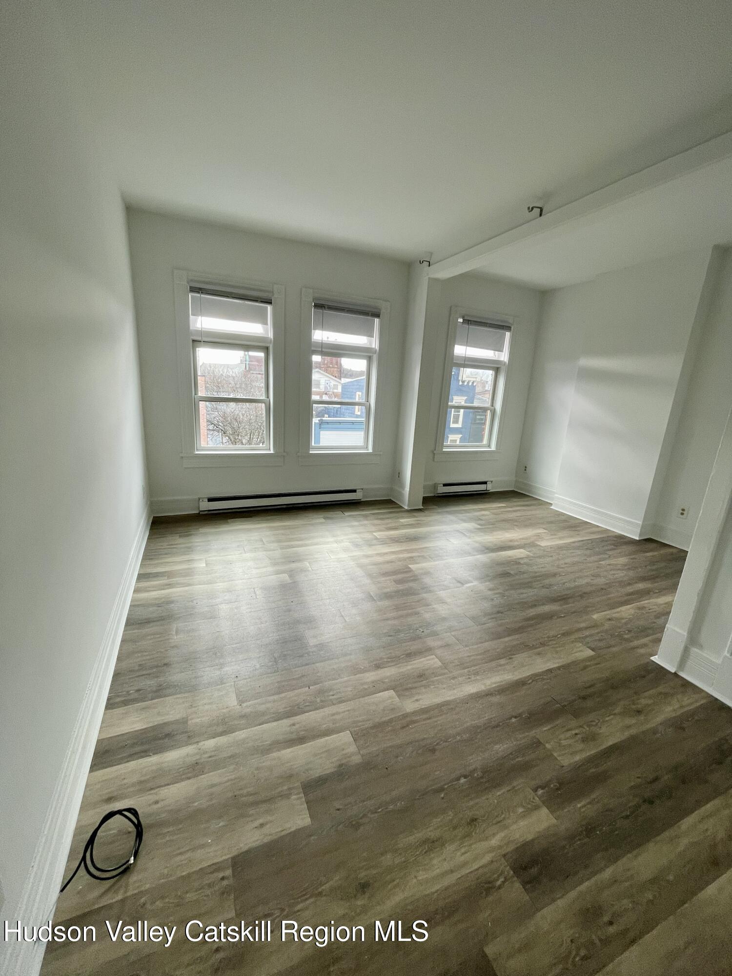 426 Warren Street, Unit 3 Hudson, NY 12534 - Photo 6 of 13 an empty room with wooden floor and windows