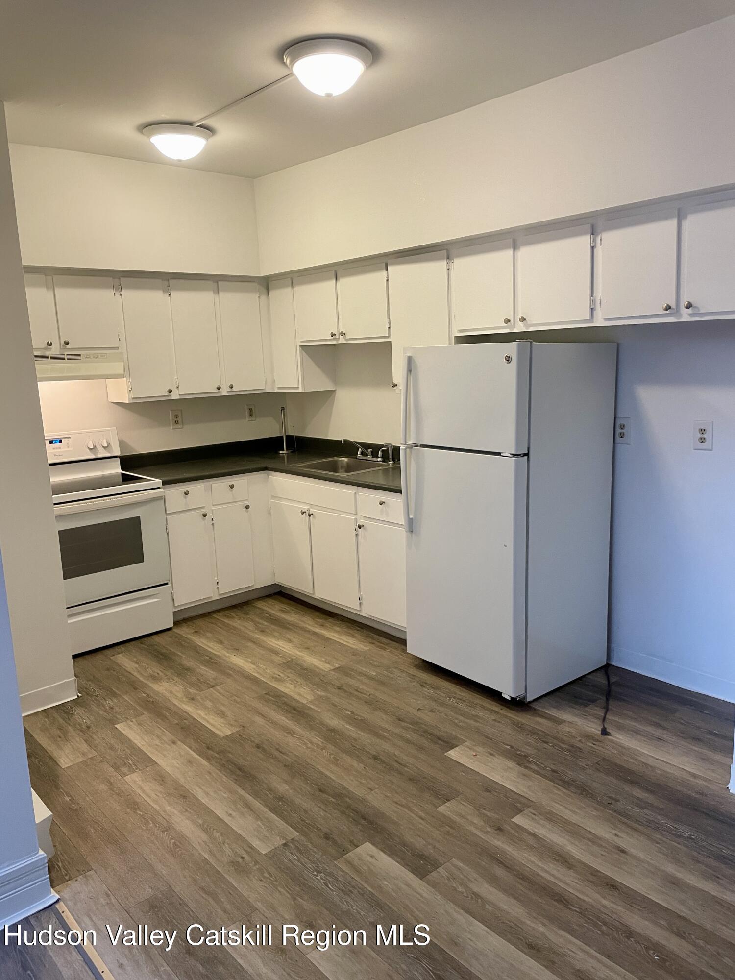 426 Warren Street, Unit 3 Hudson, NY 12534 - Photo 9 of 13 a kitchen with stainless steel appliances granite countertop a refrigerator sink and cabinets