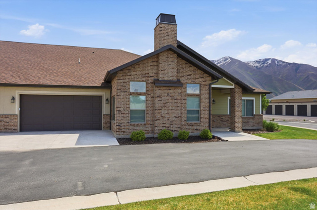 1838 West 300th Street South, Unit B Mapleton, UT 84664 - Photo 35 of 51 Brick and siding exterior featuring a two-car garage, front entry porch, and a prominent brick chimney