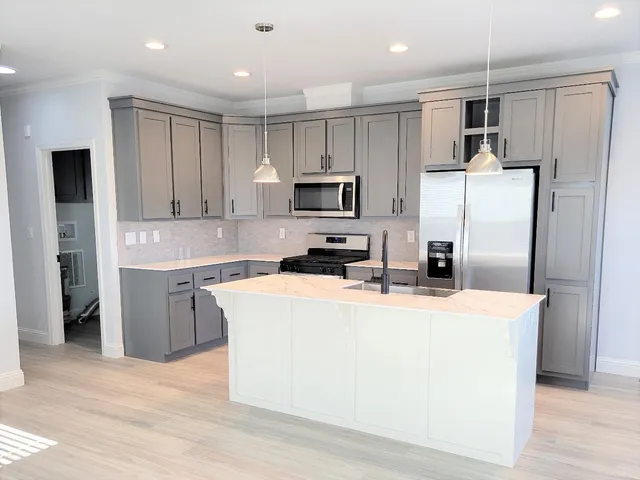 a kitchen with kitchen island a refrigerator sink and microwave