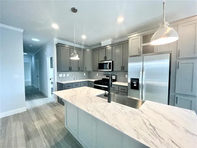 a large kitchen with a large counter top appliances and cabinets
