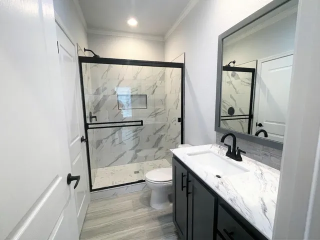 a bathroom with a granite countertop sink toilet and shower