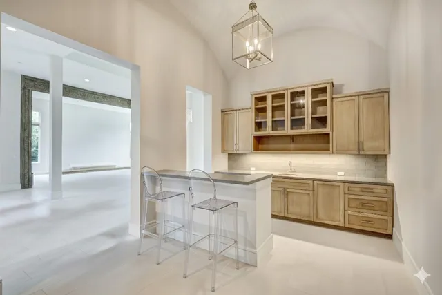 a large kitchen with kitchen island granite countertop a sink and cabinets