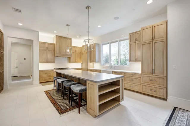 a kitchen with kitchen island a sink stove and refrigerator
