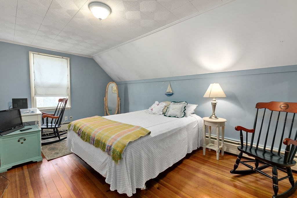 524 Merrimack Street Methuen, MA 01844 - Photo 16 of 34 a bedroom with a bed and a wooden floor