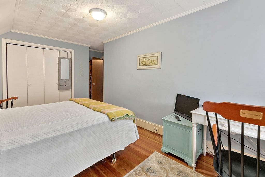 524 Merrimack Street Methuen, MA 01844 - Photo 17 of 34 a bedroom with a bed and wooden floor