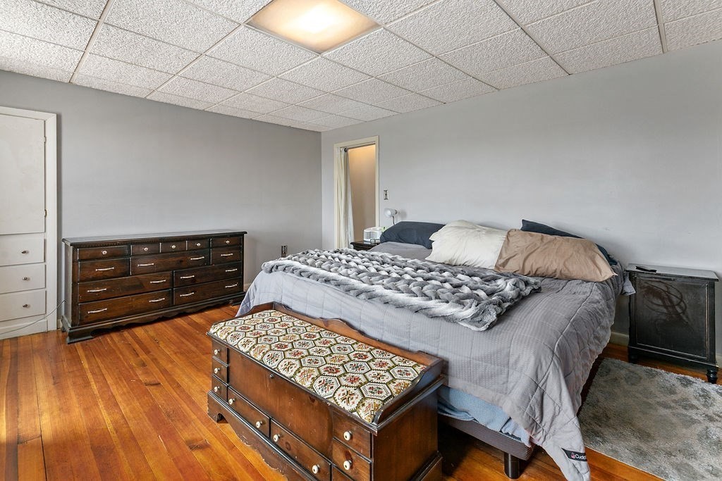 524 Merrimack Street Methuen, MA 01844 - Photo 19 of 34 a bedroom with a bed and wooden floor