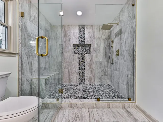 a bathroom with a shower toilet and sink