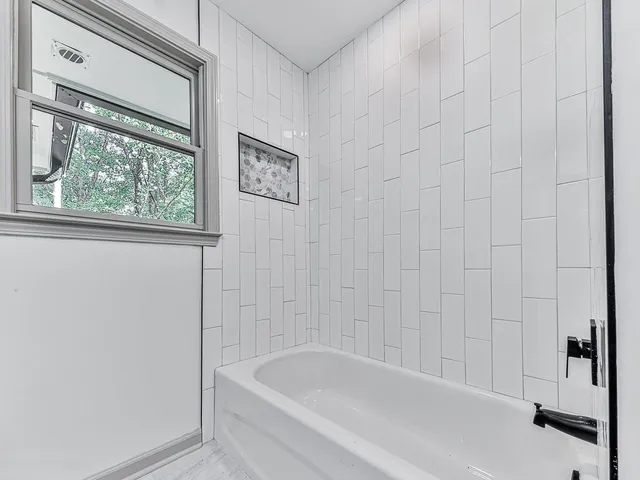 a bathroom with a bathtub and shower
