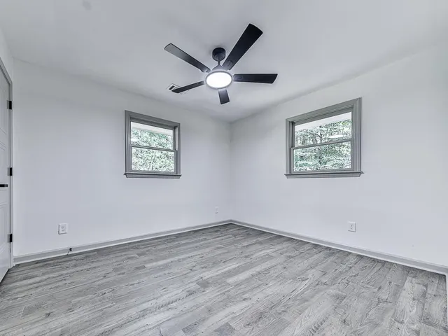 a view of empty room with wooden floor