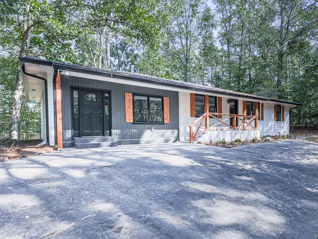 a view of a house with a patio and a yard