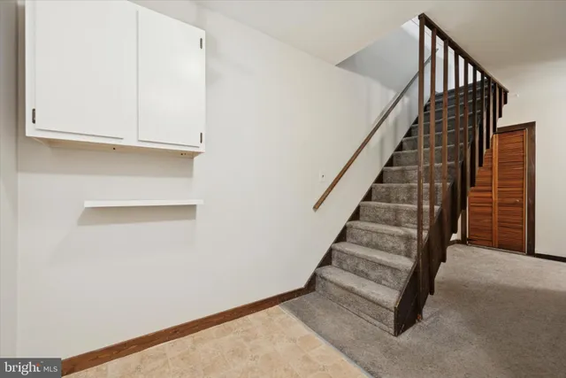 an empty room with a chandelier fan and windows