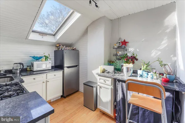 a kitchen with granite countertop a sink stove and refrigerator