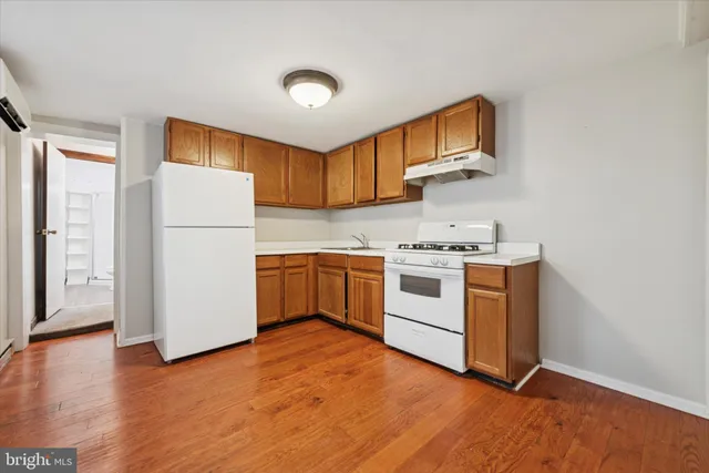 a view of a kitchen with a fridge wooden floor and a window