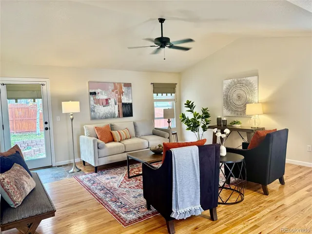 a living room with furniture and a wooden floor