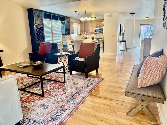 a living room with furniture and a wooden floor