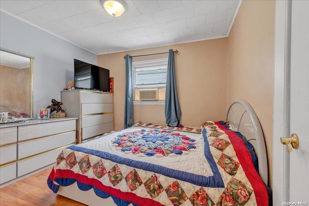 91-26 79th Street Queens, NY 11421 - Photo 11 of 20 a bedroom with a bed and a lamp on dresser