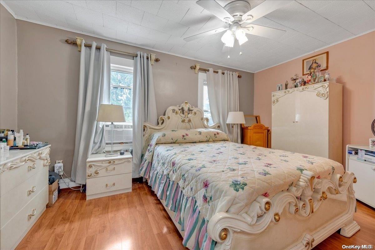 91-26 79th Street Queens, NY 11421 - Photo 12 of 20 a bedroom with a large bed and a chandelier
