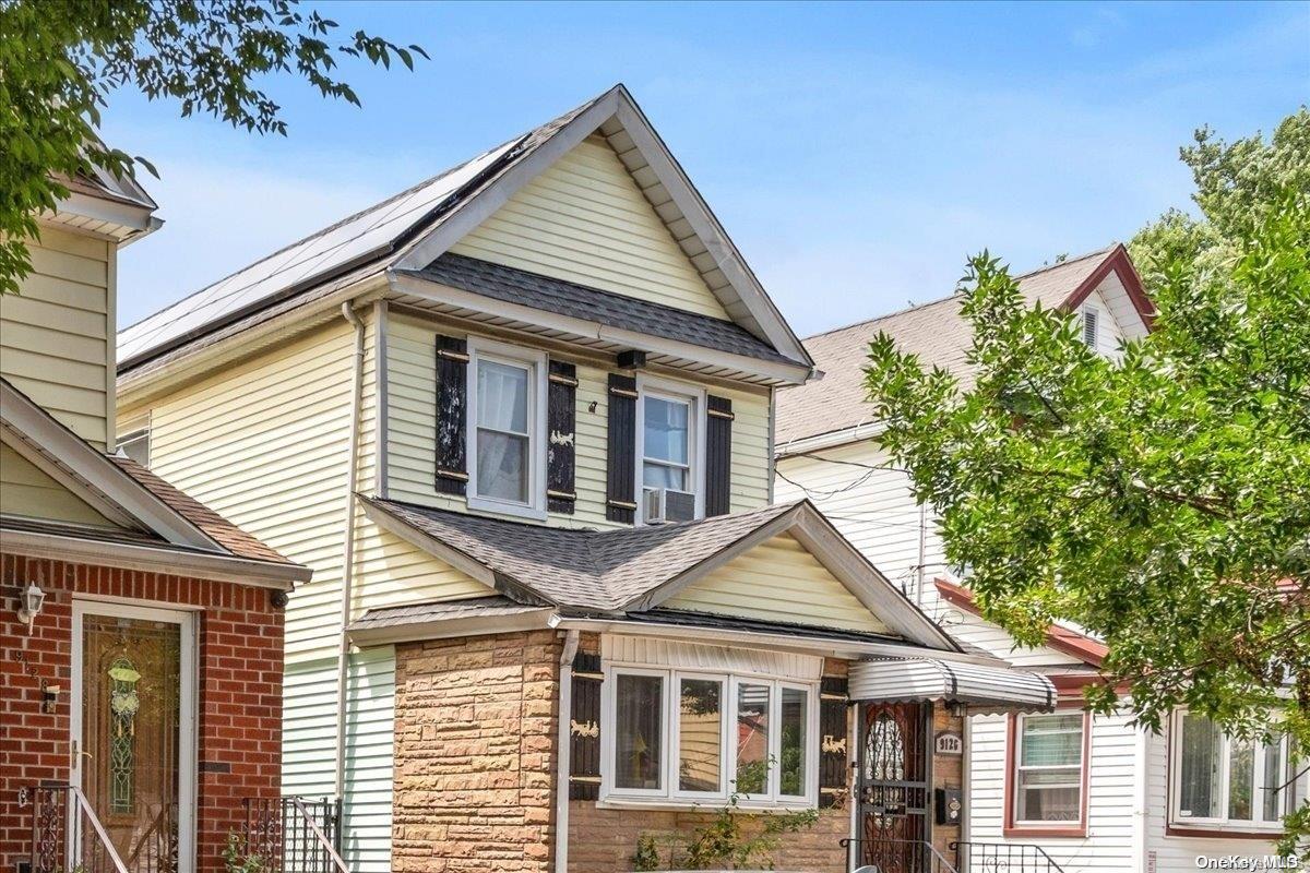 91-26 79th Street Queens, NY 11421 - Photo 18 of 20 a view of a white house next to a yard