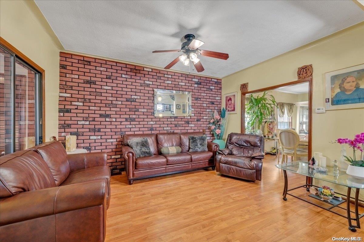 91-26 79th Street Queens, NY 11421 - Photo 4 of 20 a living room with furniture ceiling fan and a large window
