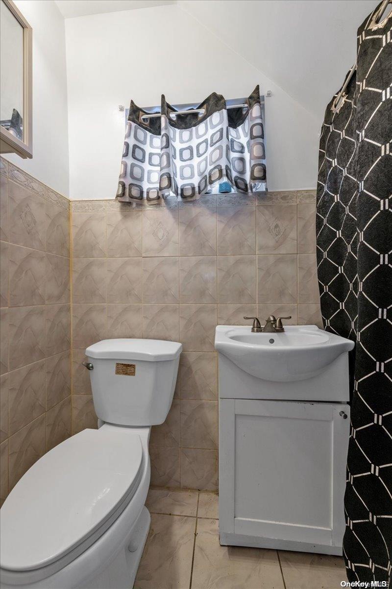 91-26 79th Street Queens, NY 11421 - Photo 8 of 20 a bathroom with a toilet sink and mirror