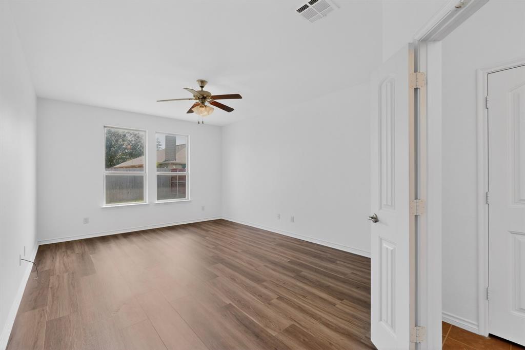 426 Harding Lane Lavon, TX 75166 - Photo 18 of 40 Spacious room featuring wood-finish flooring, white walls, and a ceiling fan with integrated lighting