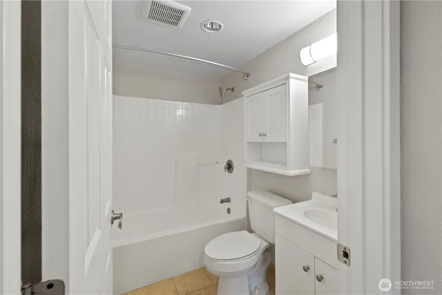 a bathroom with a granite countertop sink a toilet and shower