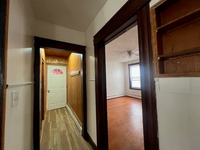 a view of a hallway with wooden floor and closet