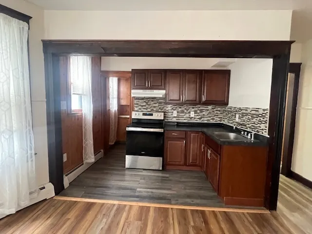 a kitchen with stainless steel appliances granite countertop a stove a sink and a refrigerator