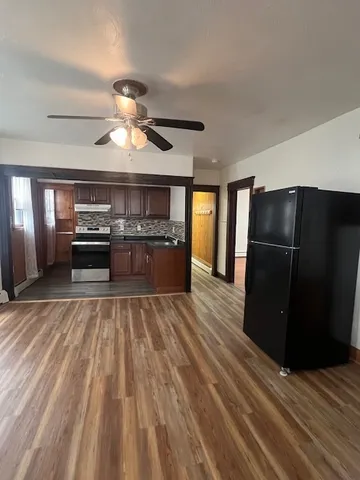 a view of kitchen with refrigerator stove and wooden floor