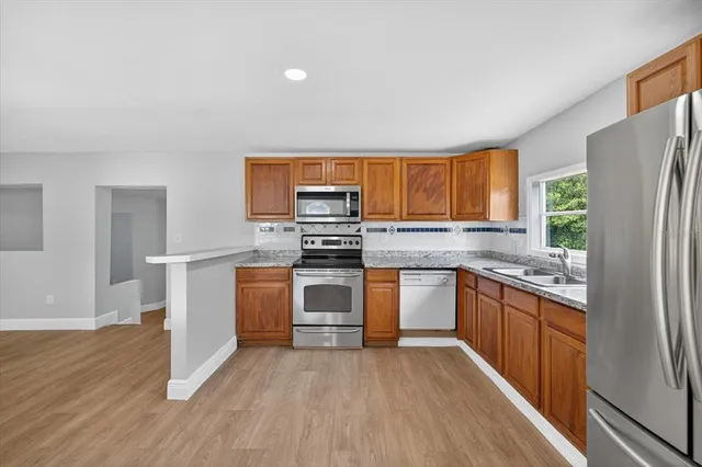 a kitchen with stainless steel appliances granite countertop a refrigerator stove and oven