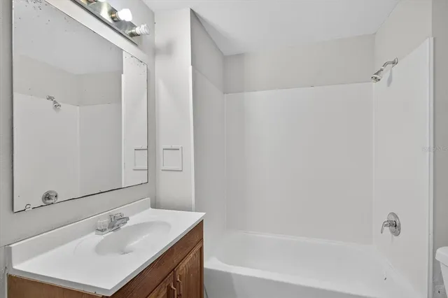 a bathroom with a sink vanity tub and shower