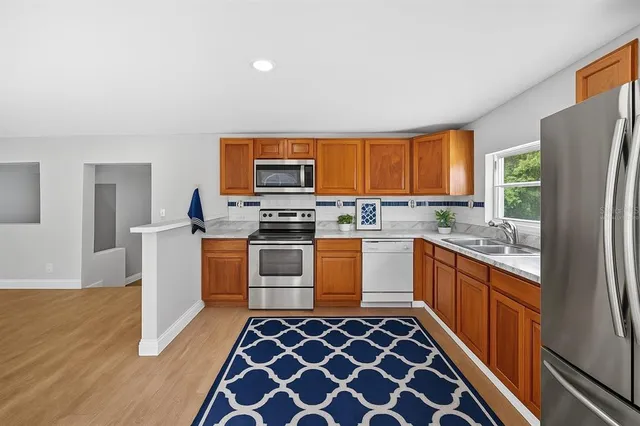 a kitchen with stainless steel appliances a refrigerator sink and stove