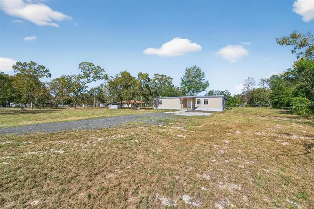 a view of a house with yard and tree s