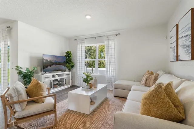 a living room with furniture fireplace and a large window