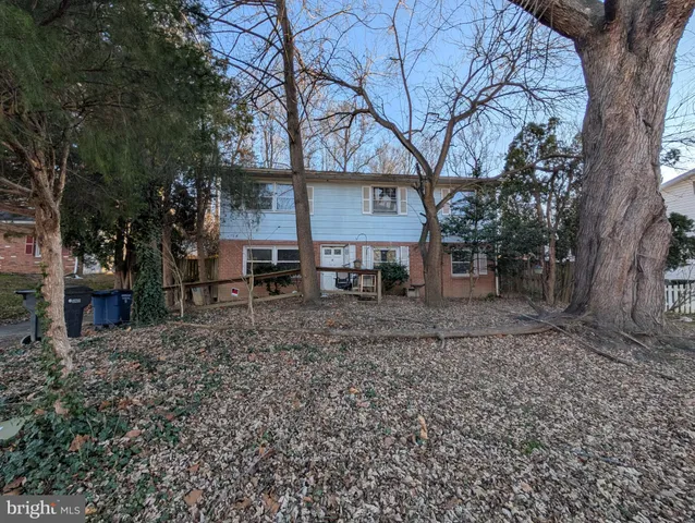 a view of a house with a yard tree and a table