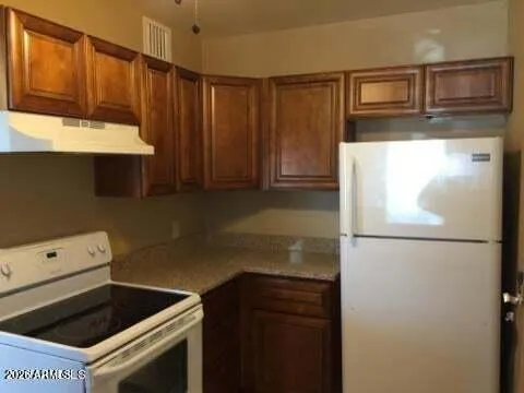 a kitchen with a refrigerator sink and cabinets