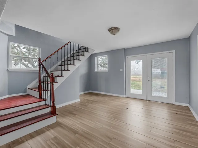 a view of empty room with wooden floor