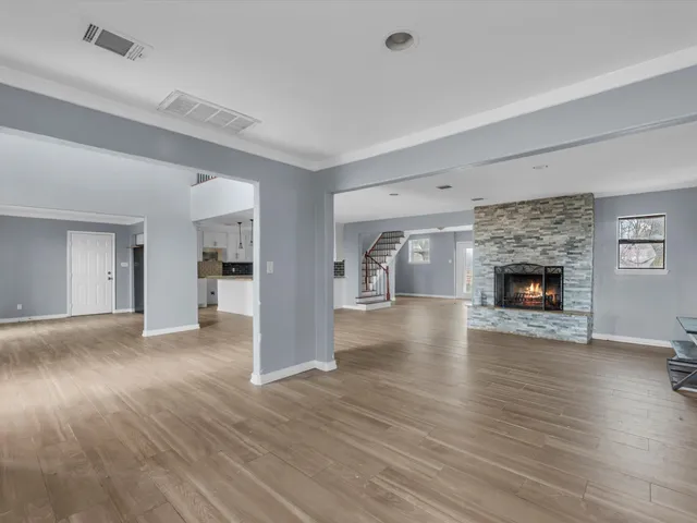 a view of an empty room with window and wooden floor