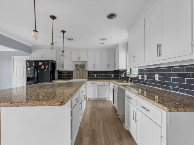 a kitchen with stainless steel appliances granite countertop a stove a sink and a refrigerator