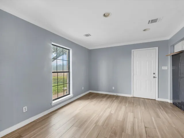 a view of a kitchen with wooden floor and a window