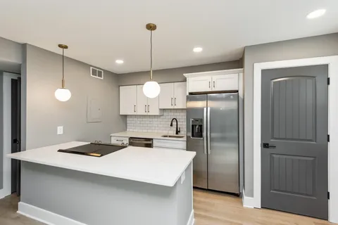 a kitchen with stainless steel appliances a refrigerator sink and microwave